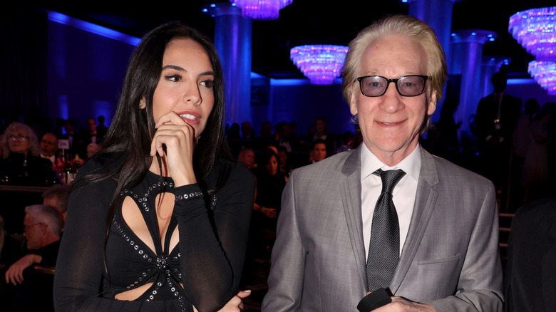 Noor Alfallah wearing black and Bill Maher in a gray suit