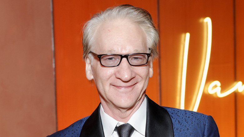 Bill Maher in a black and blue suit