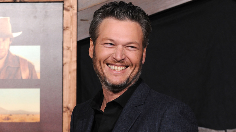 Blake Shelton wearing a black shirt and dark jacket