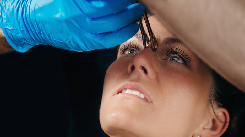 Woman getting her bridge piercing 