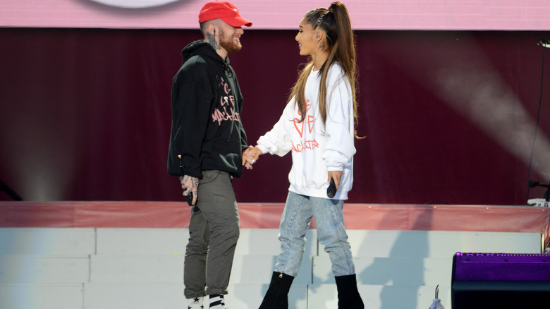 Mac Miller and Ariana Grande holding hands on stage
