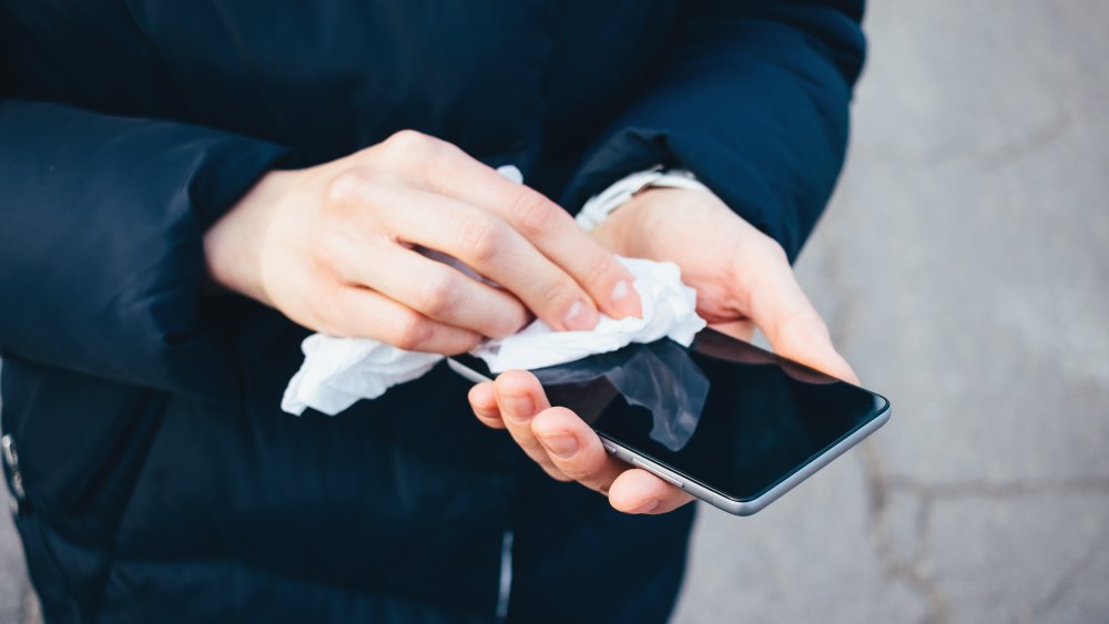 Woman wiping a cell phone