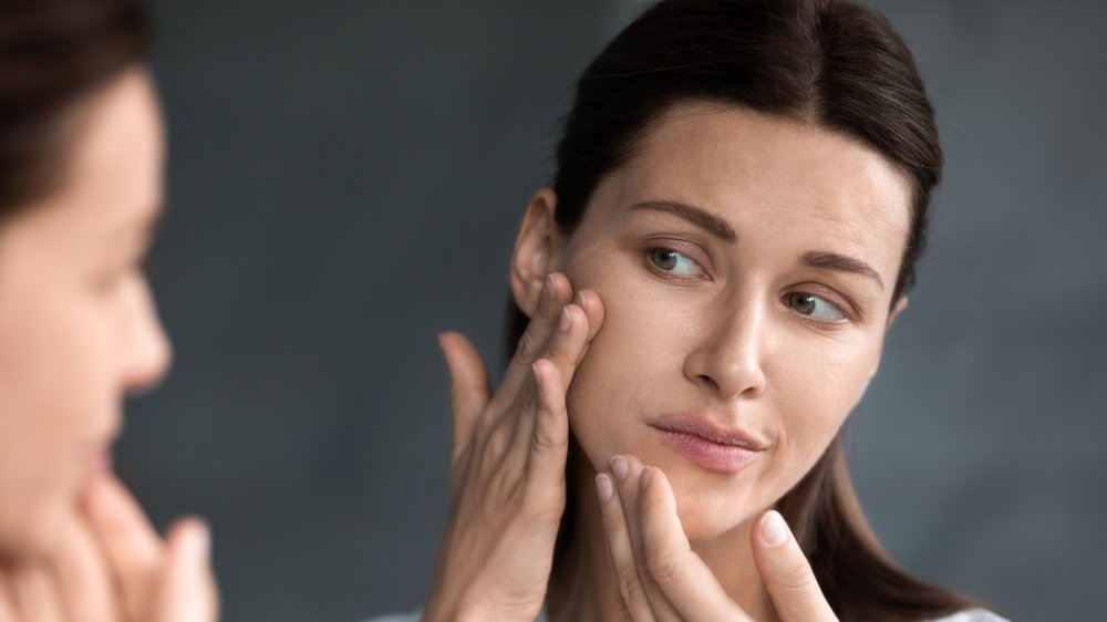 Woman looking at blemishes on her face