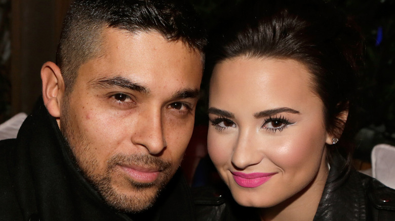 Wilmer Valderrama and Demi Lovato cuddle up at an event