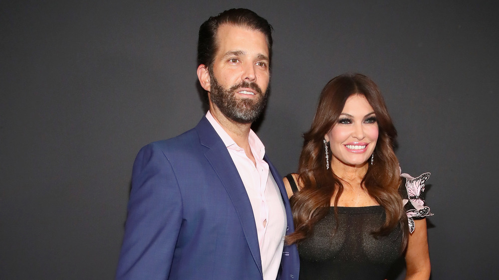 Donald Trump Jr. in blue suit and Kimberly Guilfoyle in black sheer dress