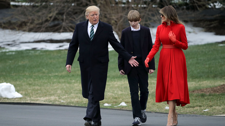 Donald, Barron, and Melania Trump walking outside