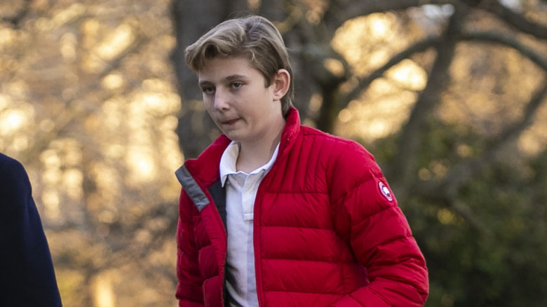 Closeup of Barron Trump walking across lawn