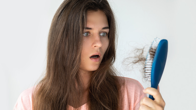 Woman losing hair in a brush