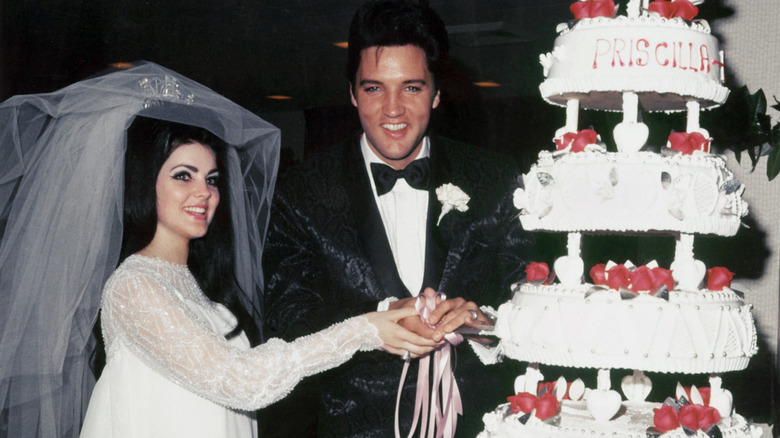 Elvis and Priscilla Presley cutting wedding cake