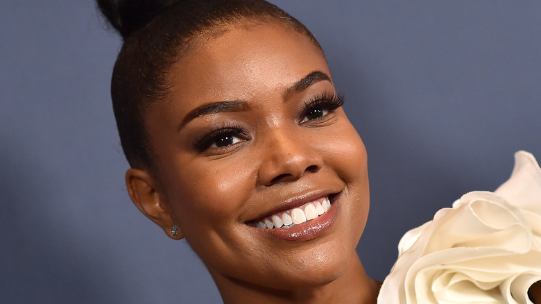 Gabrielle Union smiles with stud earrings and a bun
