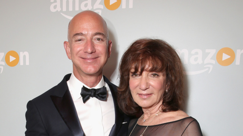 Jeff Bezos smiling in a suit next to Jackie Bezos who's wearing a black dress.