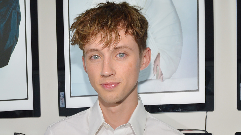 Troye Sivan smiling, wearing a nose ring 