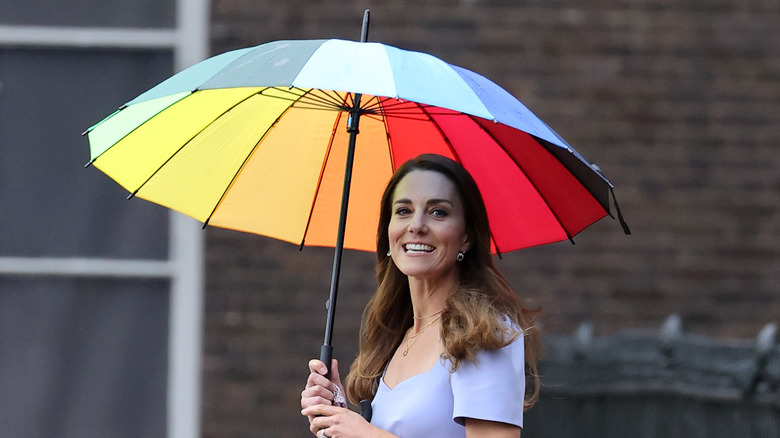 Kate Middleton smiling with umbrella