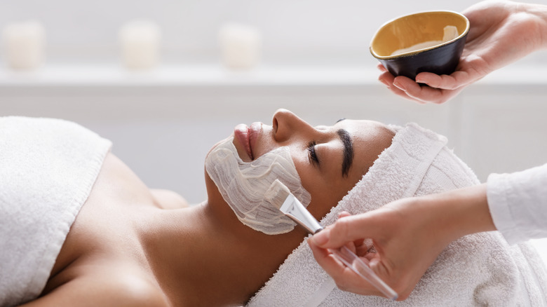 Woman applying clay face mask