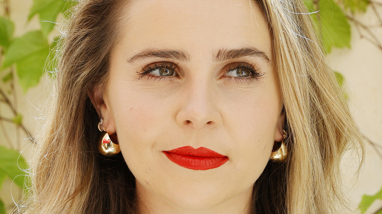 Close-up of Mae Whitman's face with leaves in the background