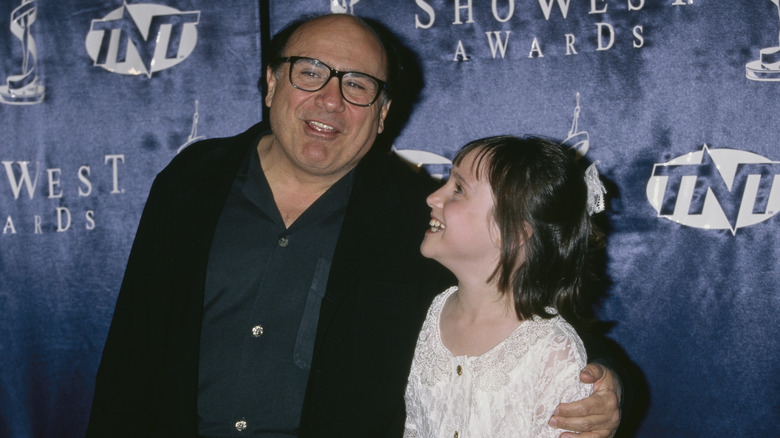 Danny DeVito and Mara Wilson smiling on the red carpet