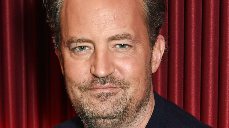 Matthew Perry grinning with facial hair