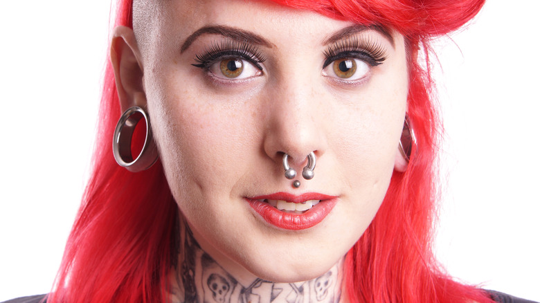 Woman with red hair and medusa piercing 