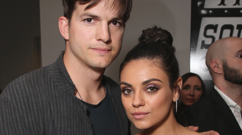 Ashton Kutcher and Mila Kunis posing at an event.