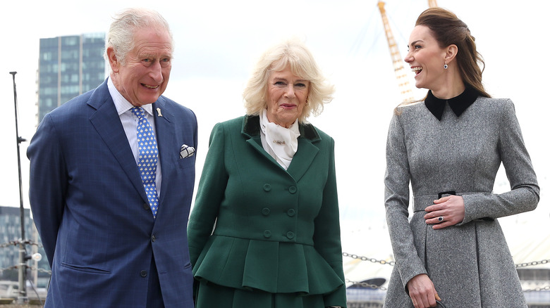 Kate Middleton laughs alongside King Charles and Camilla Parker Bowles. 