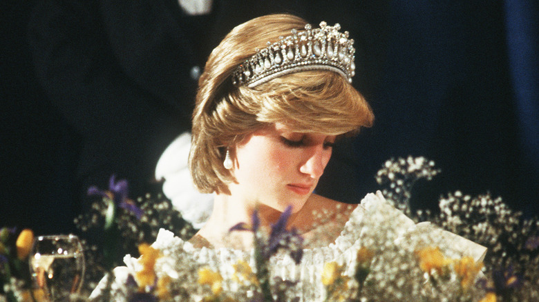 Princess Diana wearing a tiara behind flowers