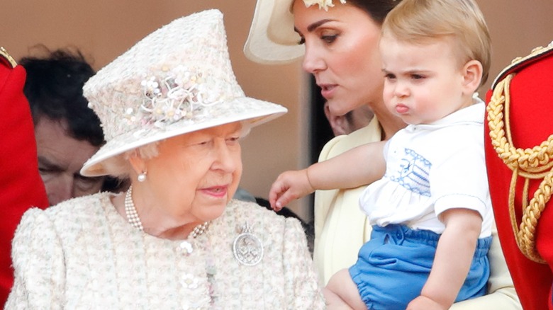 Elizabeth II, Catherine, Duchess of Cambridge and Prince Louis of Cambridge watch a flypast from the balcony of Buckingham Palace during Trooping The Colour, the Queen's annual birthday parade