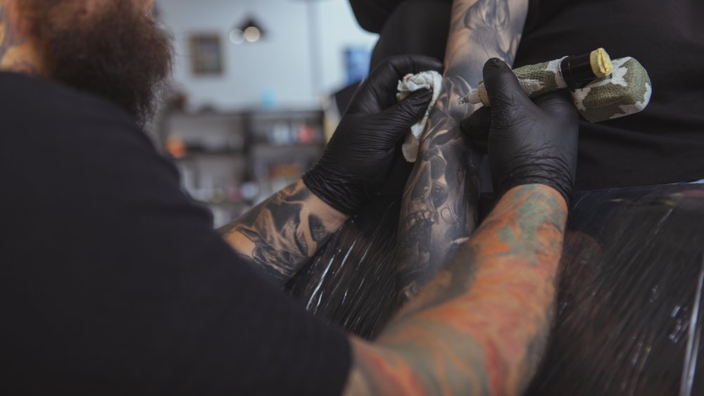 Tattoo artist working on a sleeve tattoo