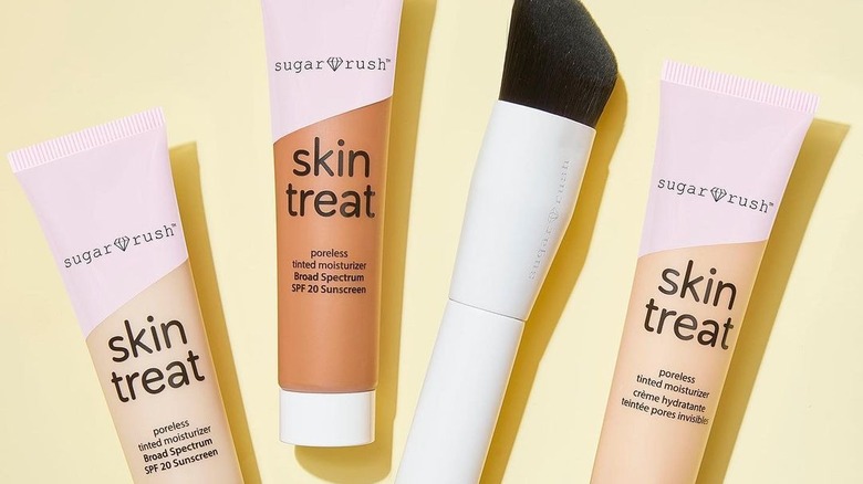 Three tubes of Tarte's Sugar Rush Poreless Tinted Moisturizer and one makeup brush 