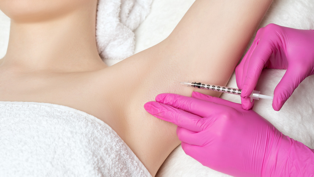 A woman receiving an injection in her armpit 