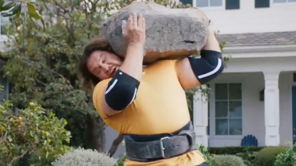 The Strong Man In GEICO's World's Strongest Man Commercial lifts a rock