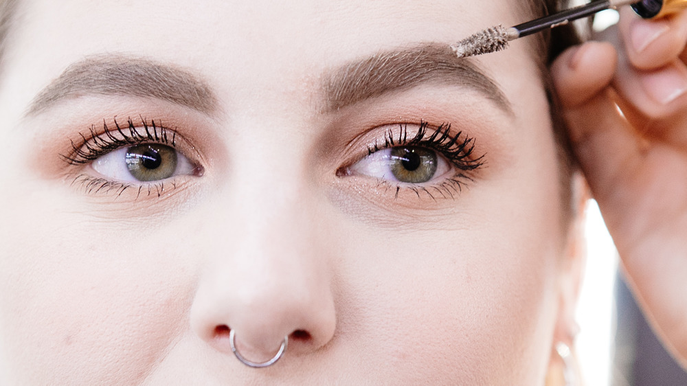 Woman applying eyebrow gel