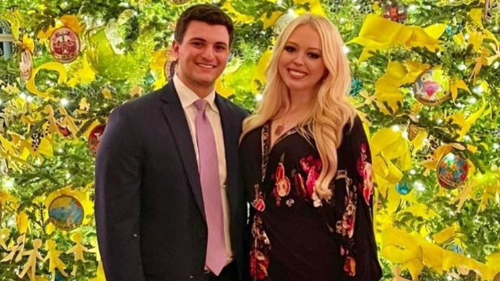 Tiffany Trump and her fiancé Michael Boulos pose in front of a Christmas treee