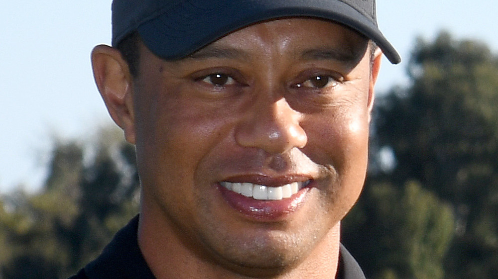 Tiger Woods smiling in baseball hat