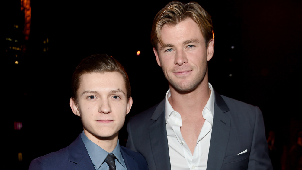 Tom Holland and Chris Hemsworth smiling