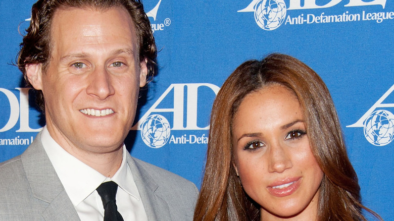 Meghan Markle (R) and Trevor Engelson smiling together