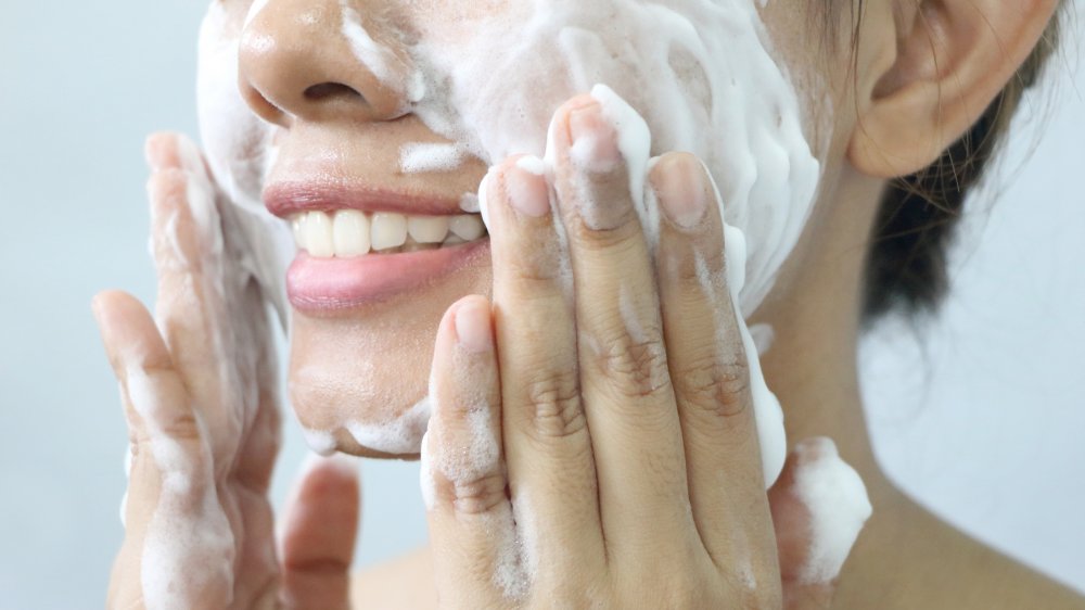 Woman washing her face with lather