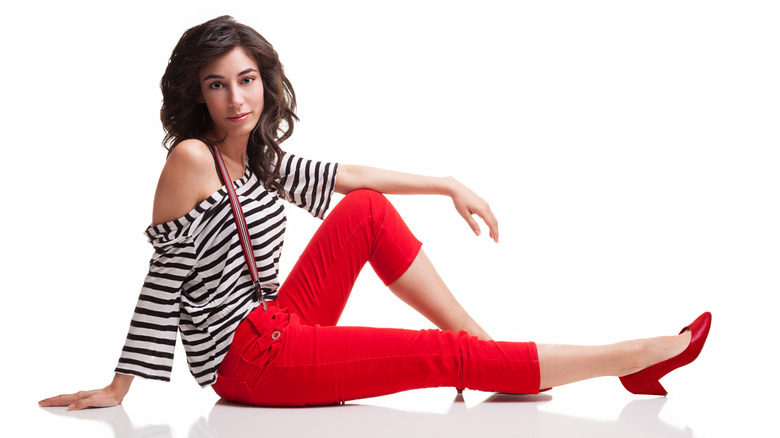 A woman wearing red capri pants and red pumps 