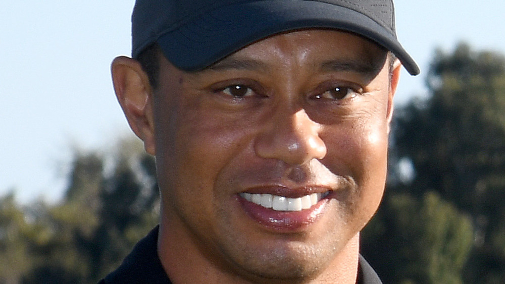 Tiger Woods smiling in baseball hat