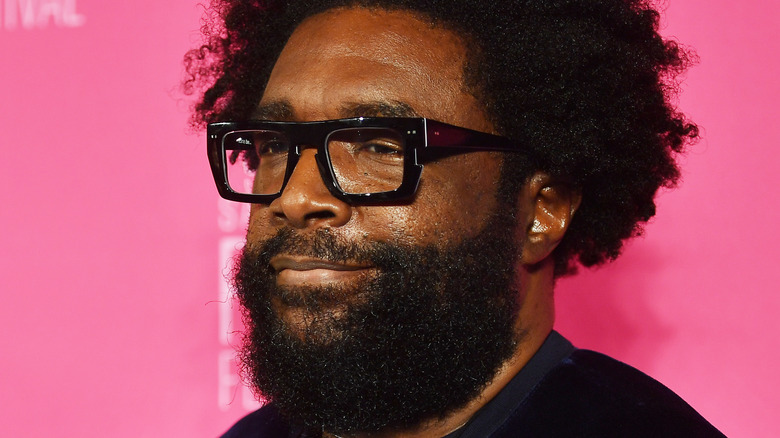 The Roots drummer Questlove against a pink background