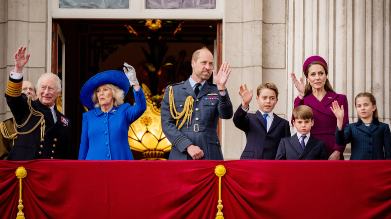 King Charles III, Queen Camilla, Prince William, Prince George, Princess Catherine, Prince Louis and Princess Charlotte waving on the balcony of Buckingham Palace.