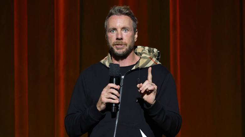 Dax Shepard holds a microphone onstage