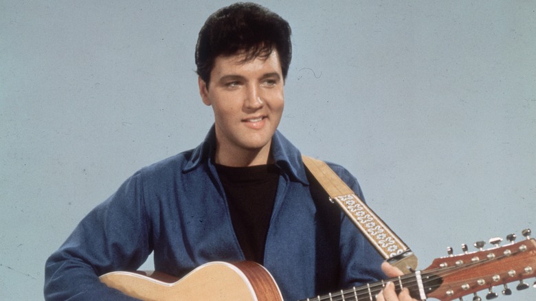 Elvis Presley smiling with guitar