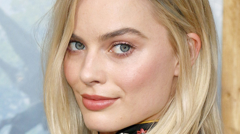Margot Robbie looks over her shoulder on the red carpet