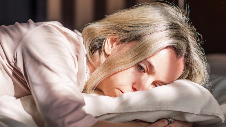 sad woman laying on pillow