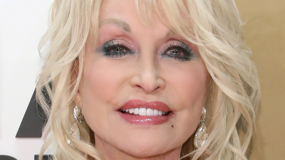 Dolly Parton smiling with an award