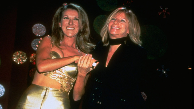 Celine Dion holding hands with Barbra Streisand onstage