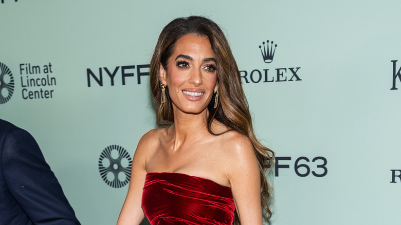 Amal Clooney smiling on a red carpet