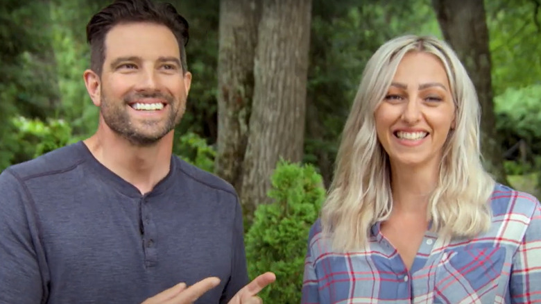 Scott McGillivray and Debra Salmoni smiling while filming a segment for their show