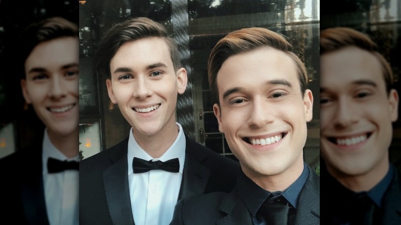 Clint Godwin and Tyler Henry in black suits posing for a picture together.