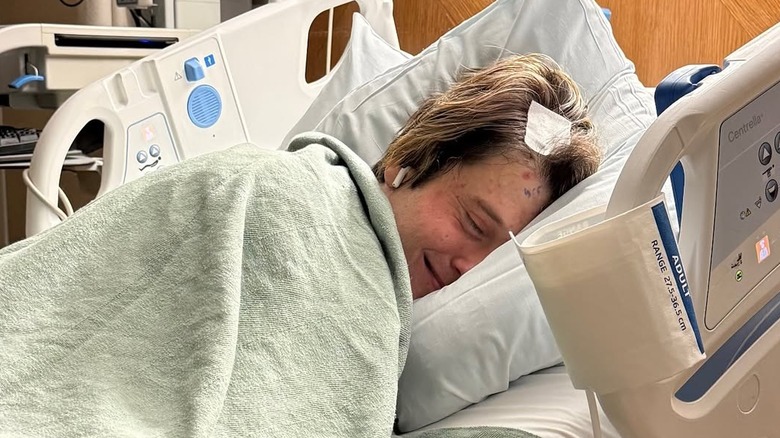 Tyler Henry in a hospital bed recovering from brain surgery